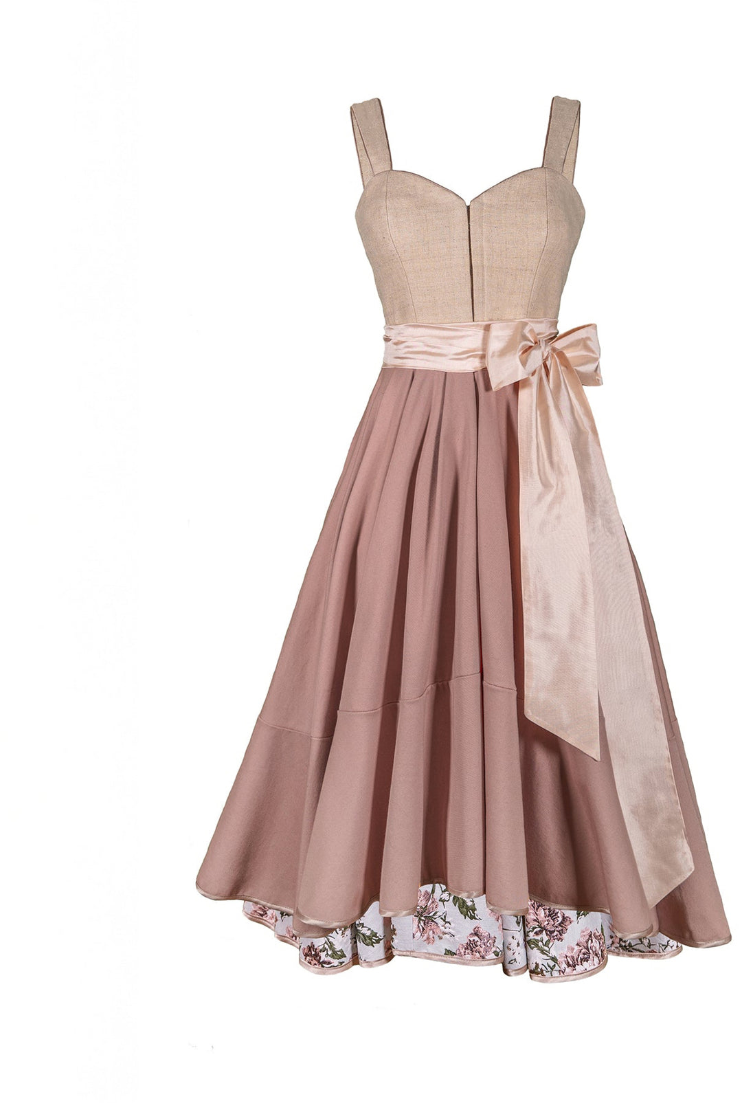 Ein freigestelltes Dirndlkleid in rosa Cremetönen ohne Schürze mit einer hellrosa Schleife. Das Dirndl hat ein weit ausgestellten Rock und auf der Innenseite des Saums ebenfalls Florale Muster