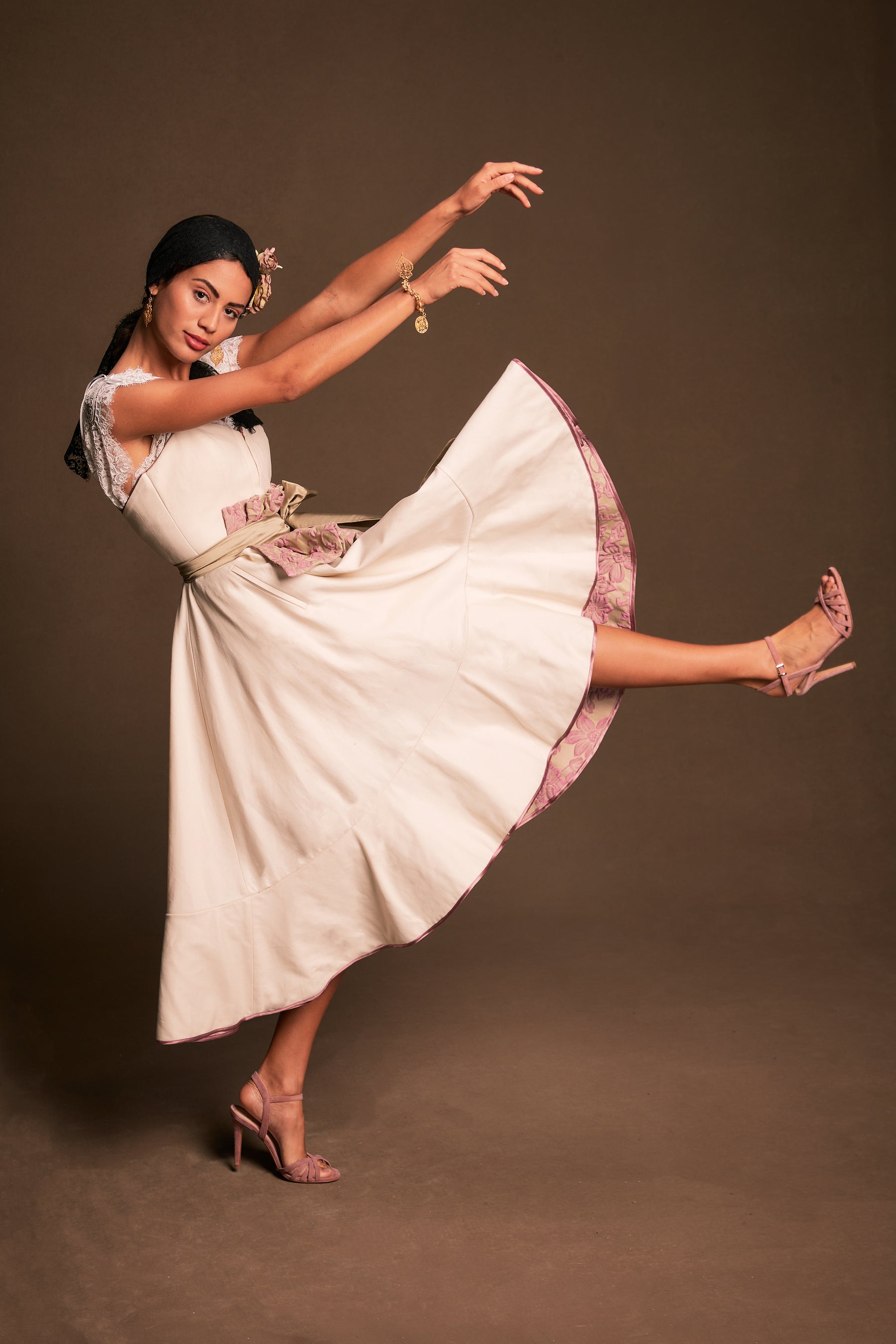 Modell Kleid Lourosa von Policarpo Trachten in hellem creme schwungvoll tanzender Bewegung präsentiert, Rockinnenseite aus floral strukturiert griffigen Jacquard in Rosetönen