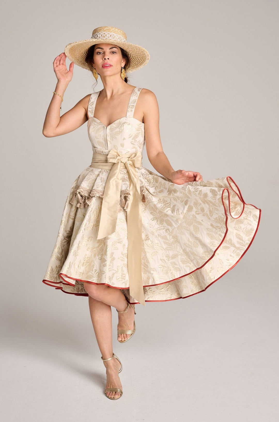 Ein elegantes Hochzeitsdirndl getragen von einer brünetten jungen Frau mit einem Strohhut und ohne Schürze