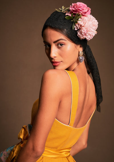 Ein Foto von Kopf bis Hüfte zeigt ein Dirndl von der Seite des Rückens eines rückenfreies Sonnenblumengelben Kleides.
